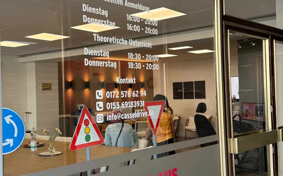 Schaufenster der Fahrschule Cassel Drive mit den Bürozeiten